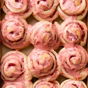 Strawberry Iced and Blackberry-Filled Roll Donut With Strawberry Drizzle and Sprinkles