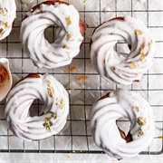 Lemon-Filled Powdered Sugar Chocolate Cruller With Banana Drizzle and Pistachios