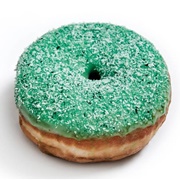 Blue Iced and Whipped Cream-Filled Pumpkin Ring Donut With Blue Drizzle and Coconut