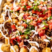 Tater Tots Loaded With Pulled Pork, Lime Slaw, Sour Cream + Green Onions